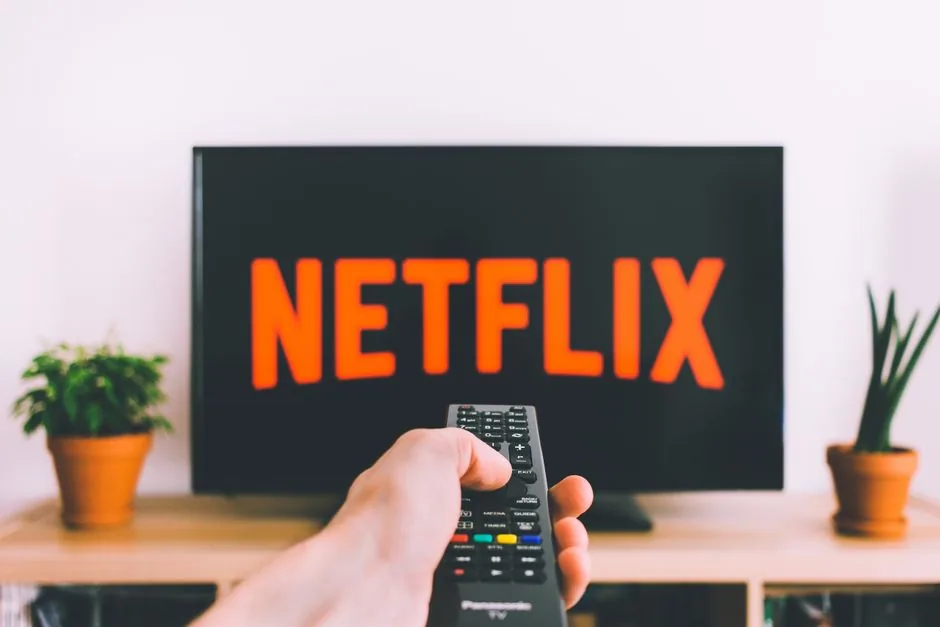 A person browsing shows on a streaming app from a couch