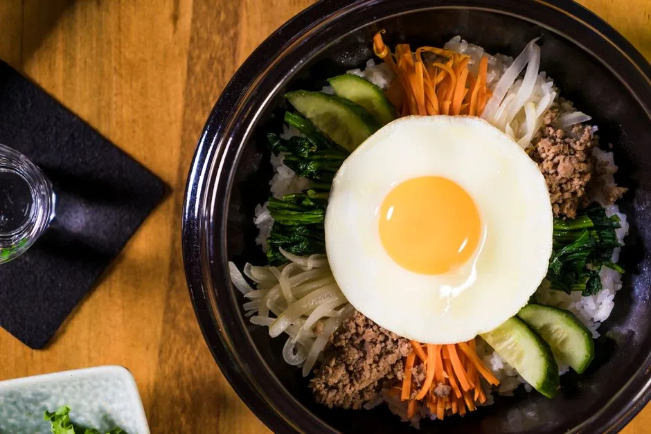 A bibimbap bowl with arranged vegetables and an egg