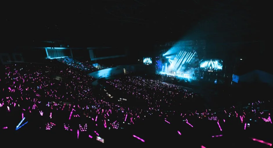 A K-pop concert stage with fans