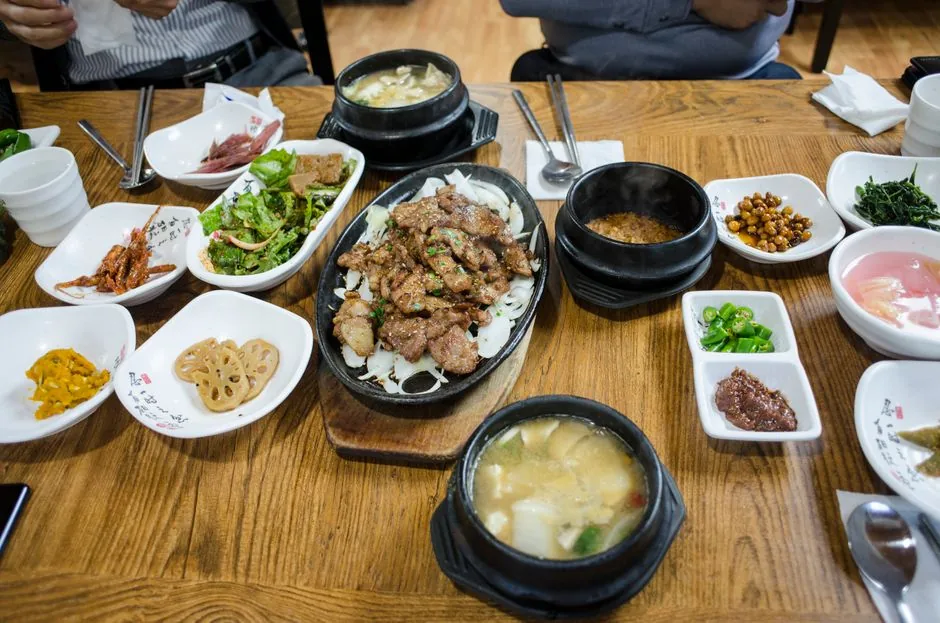 A spread of Korean dishes and side plates on a table