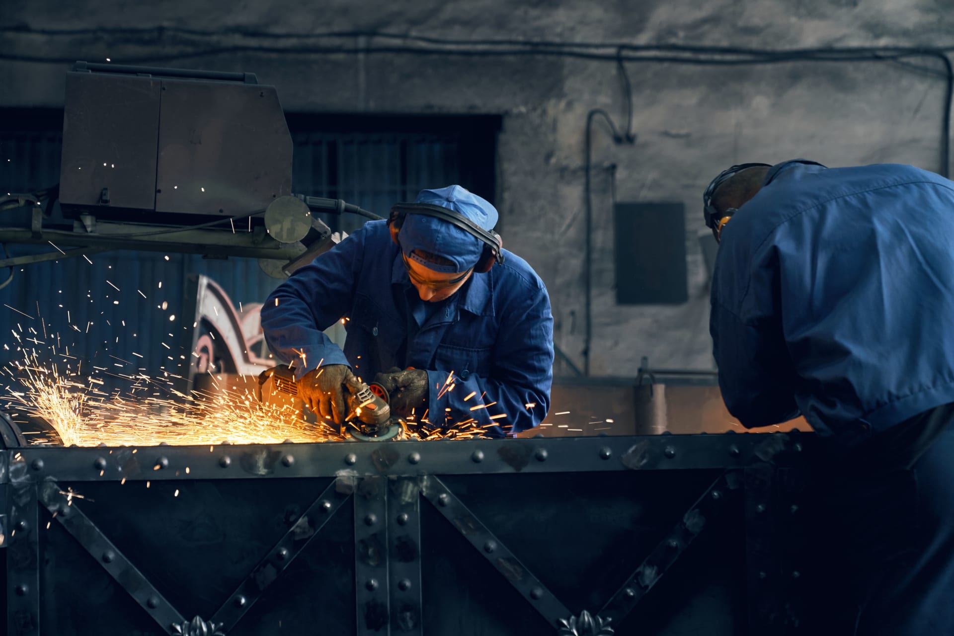 Dua pekerja sedang mengelas rangka stainless steel di bengkel produksi Rekayasa Manufaktur