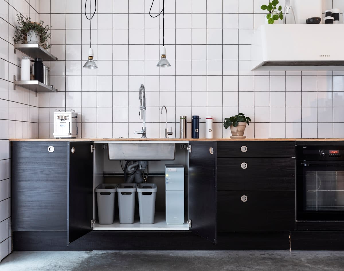 Modern sustainable kitchen with composting bins and fresh herbs