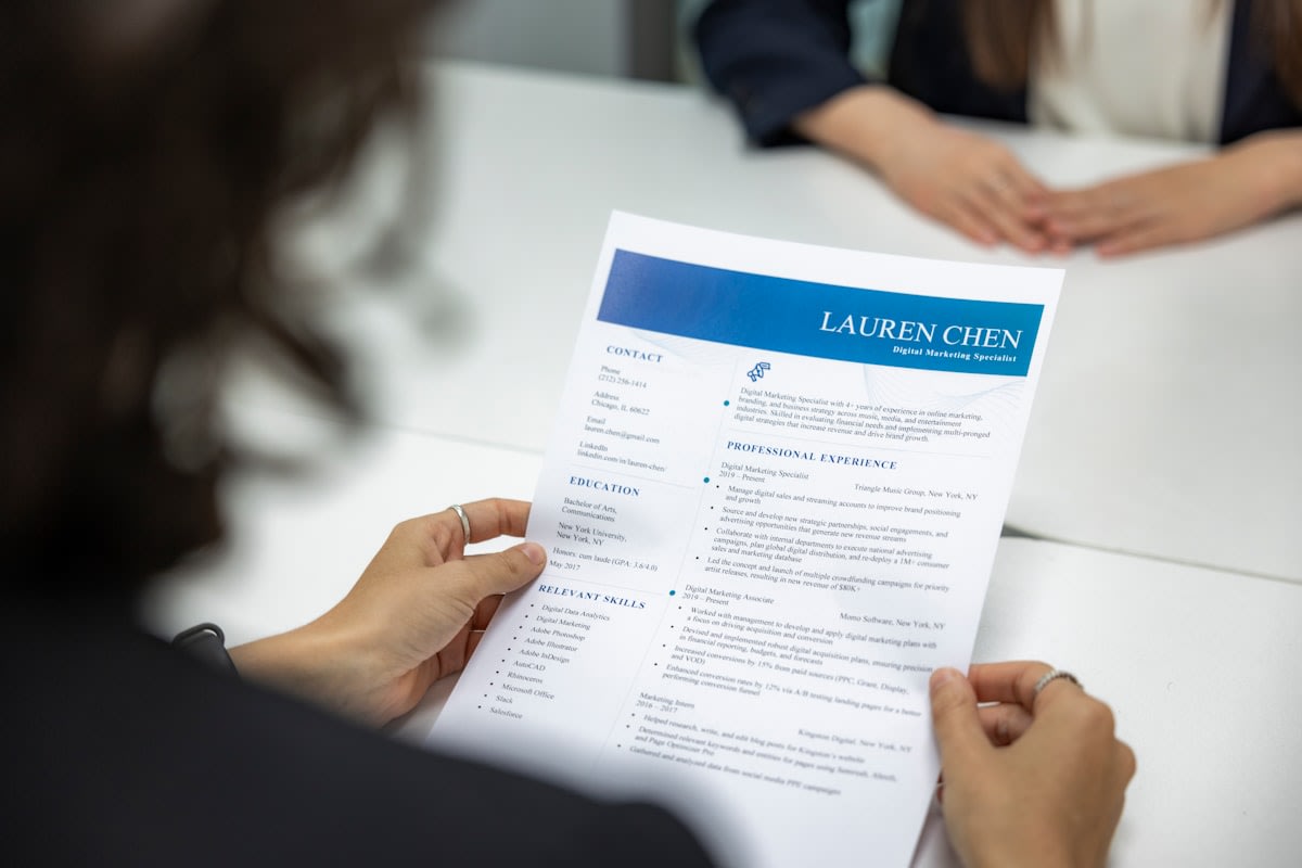 Close up of a professional resume and a laptop