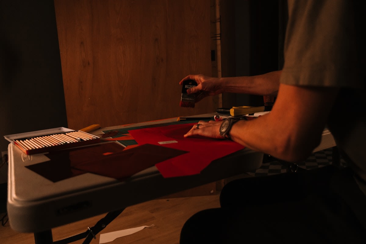 close up of a master craftsman working on a high end leather piece in a dimly lit studio