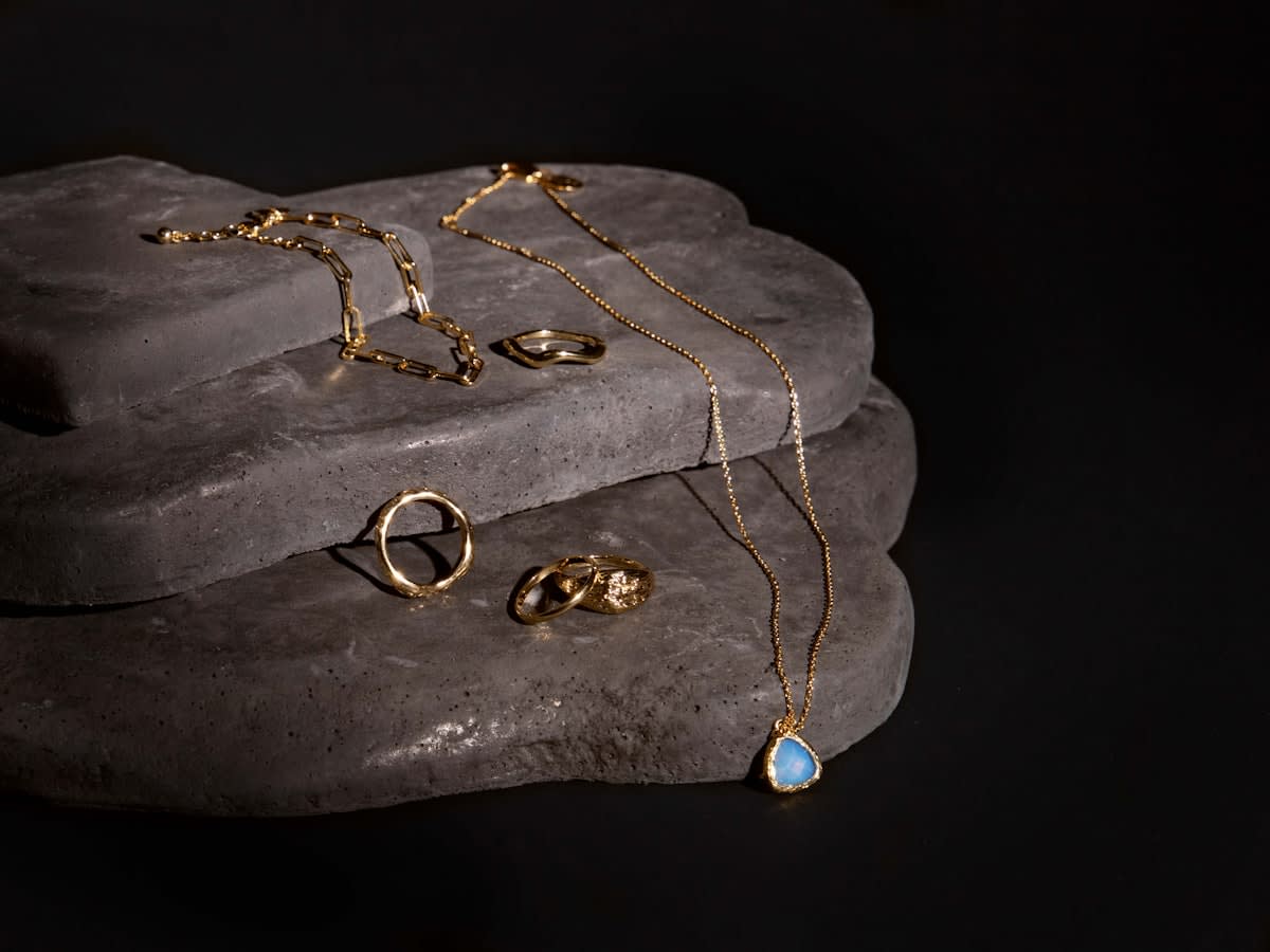 minimalist high jewelry pieces displayed on a raw stone surface