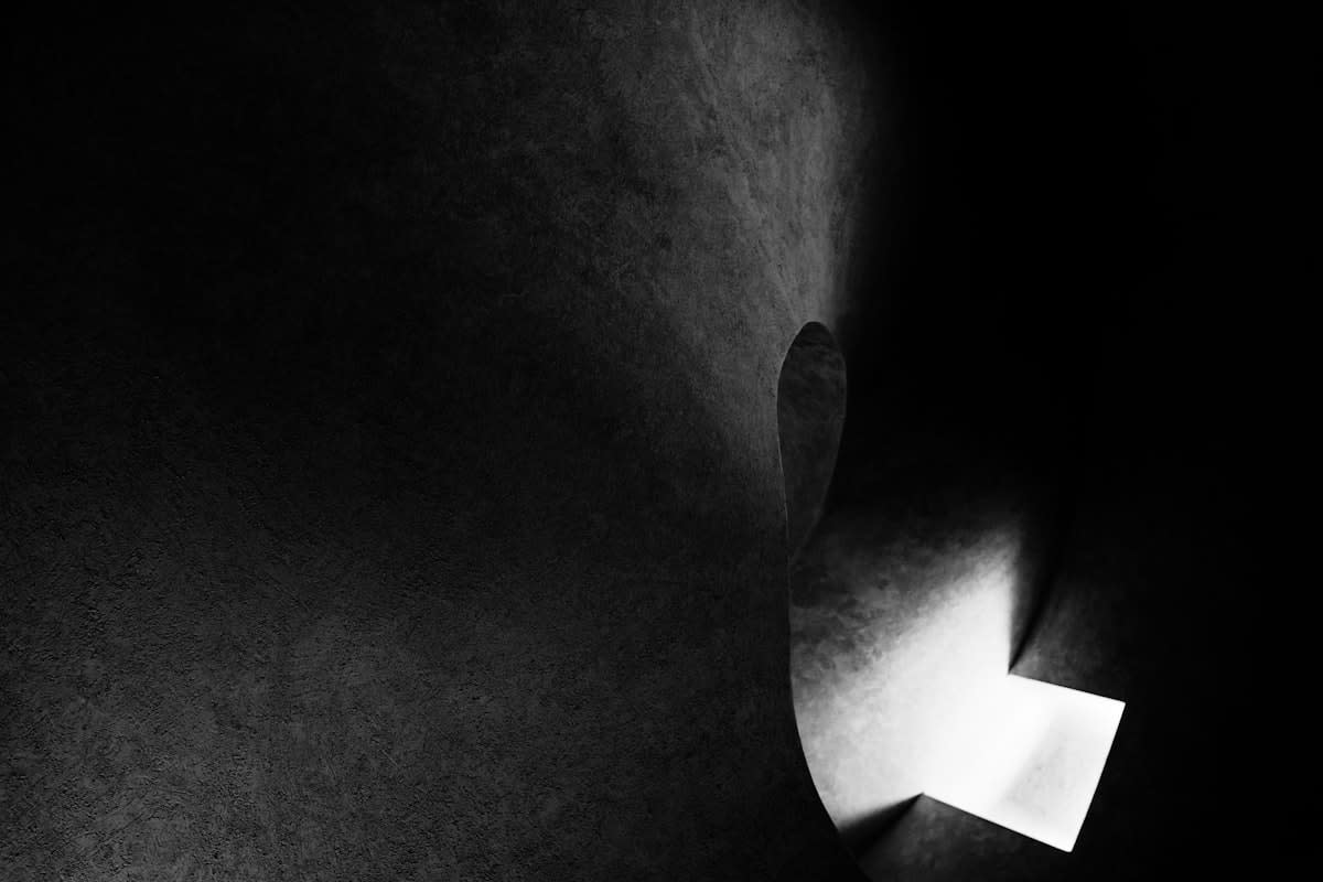 Abstract image of a person looking through a narrow slot of light