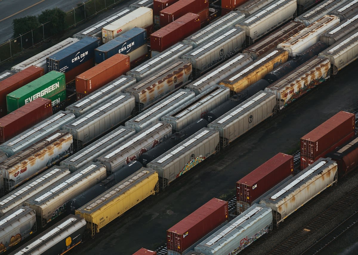 Aerial view of a modern intermodal logistics hub with trains and trucks