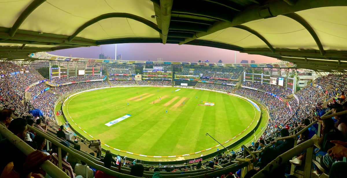 Crowded cricket stadium in India with bright floodlights