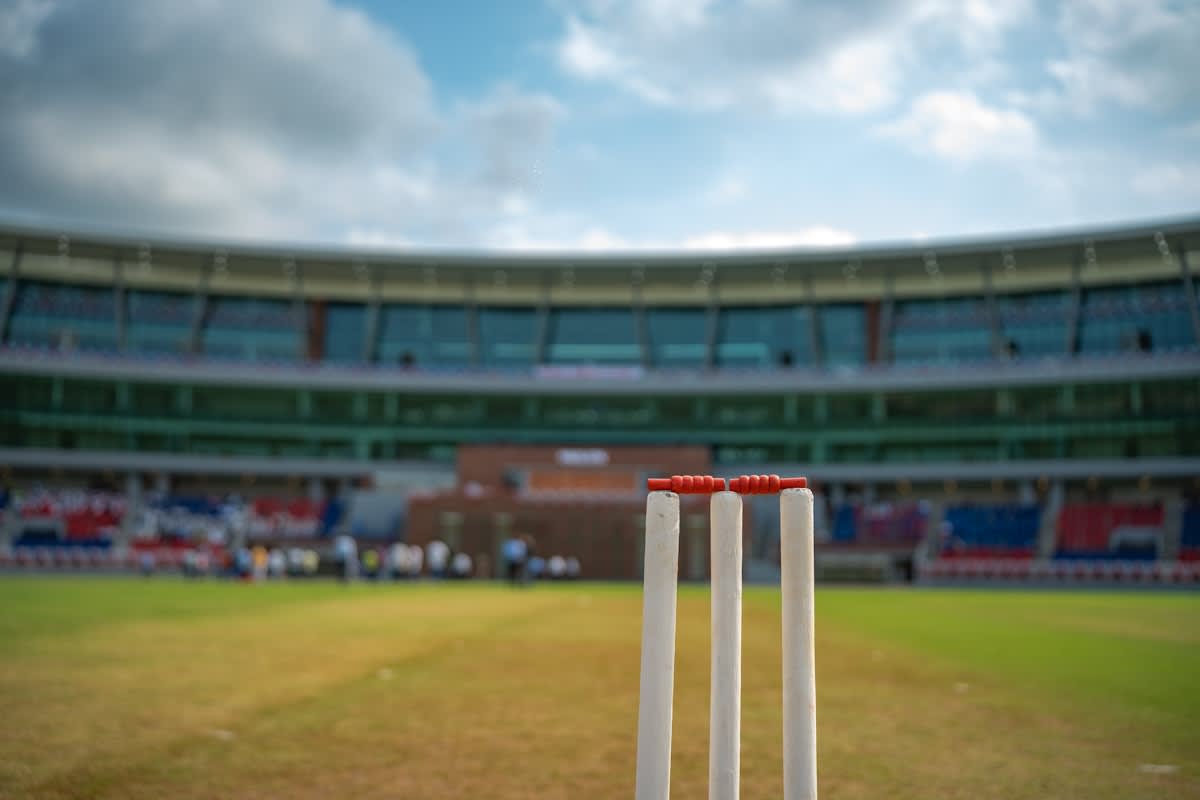 Close up of a cricket ball on a grass pitch
