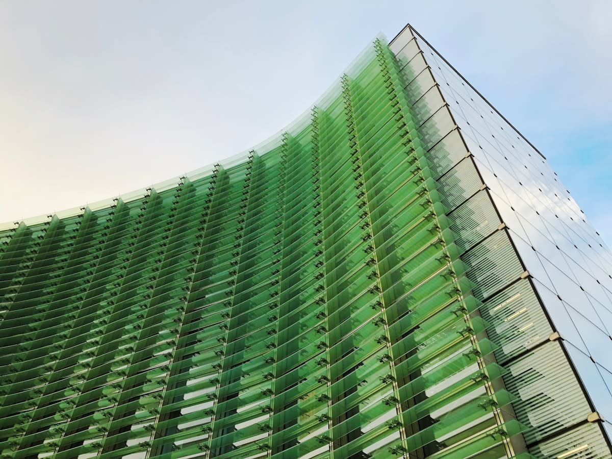 Modern corporate skyscraper reflecting a green city