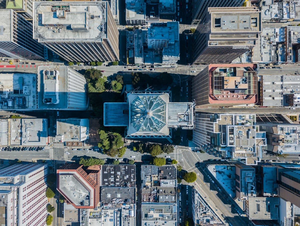 Aerial view of a dense city with robotic delivery units