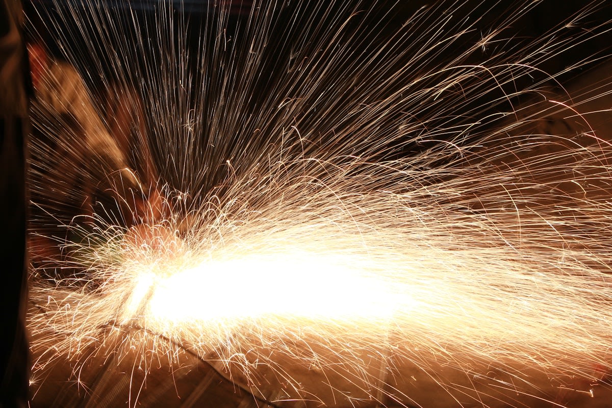 A high-contrast image of a spark hitting steel