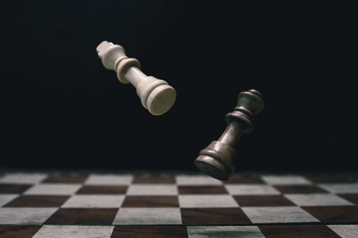 abstract chess pieces falling over