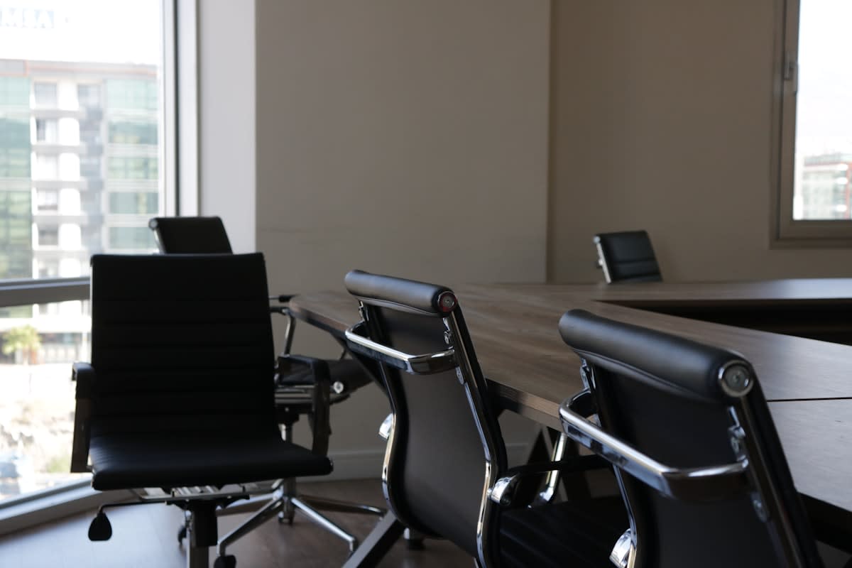 A high-end corporate office with a single empty chair facing a window