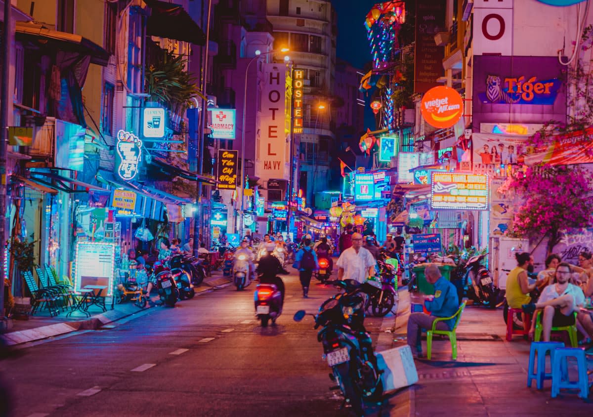 Busy Southeast Asian street market with digital signage