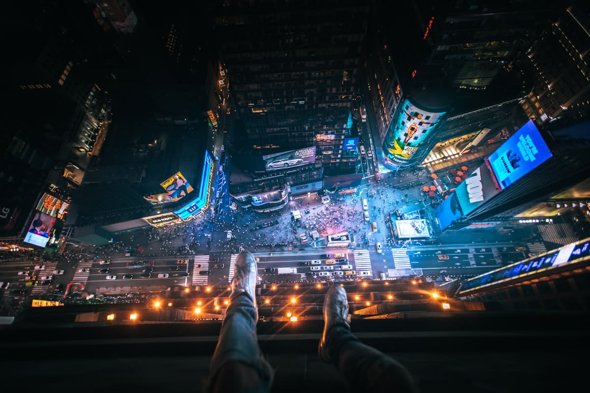 A person looking at a smartphone screen reflecting a glowing digital grid over a dark city street