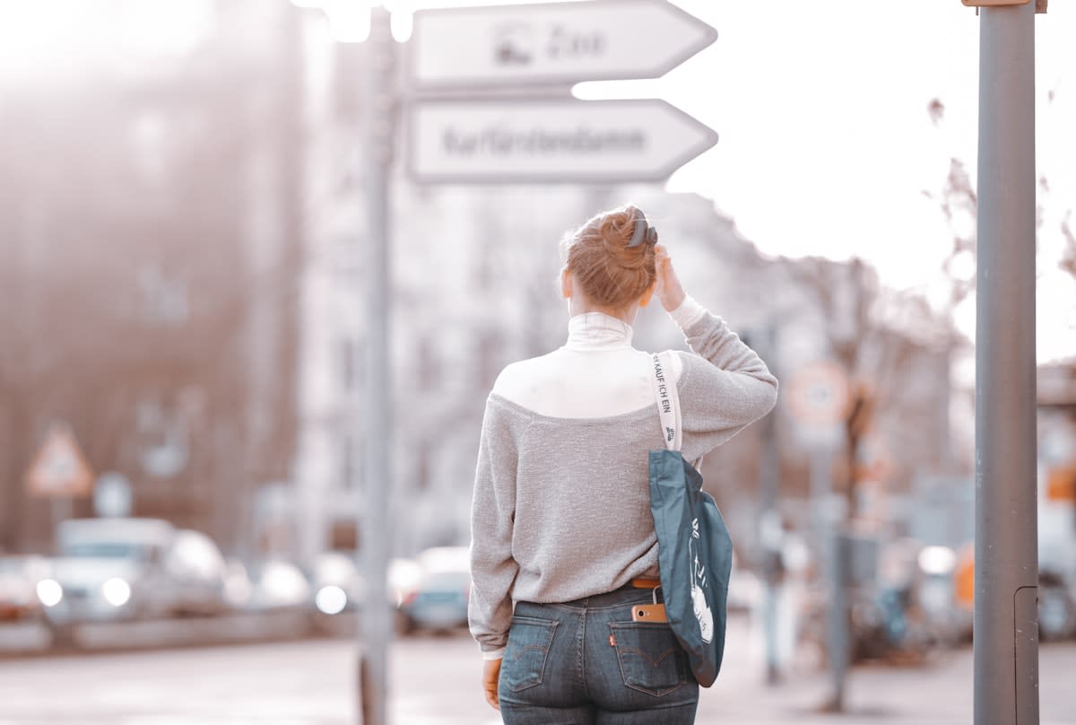 a person standing at a crossroads with clear signposts