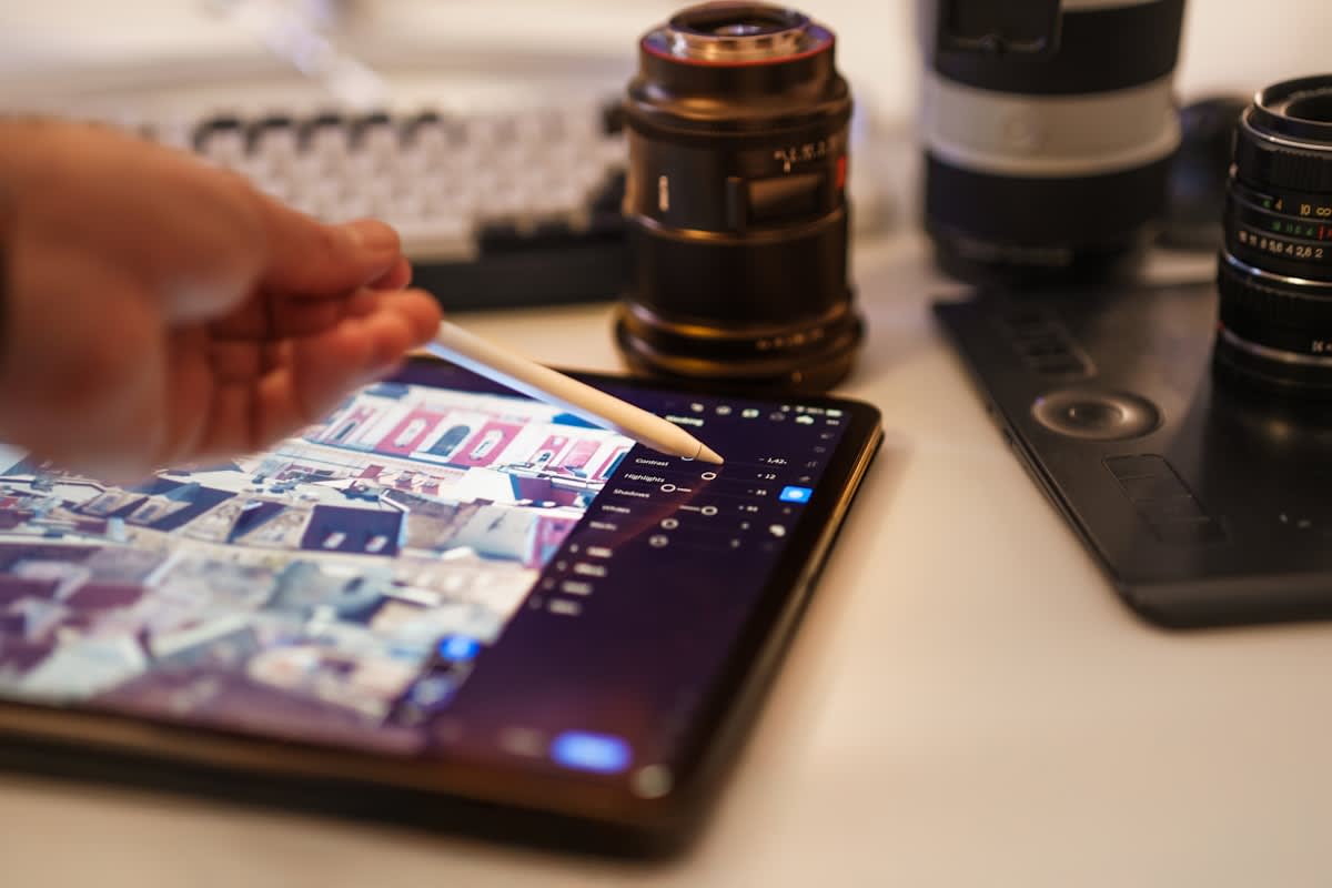 Close up of a hand editing a photograph, showing the interface and the result