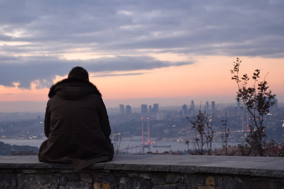 Sunrise over a cityscape with a person meditating