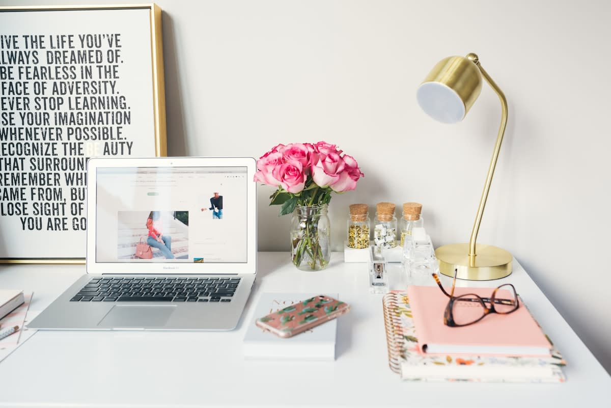 A clean desk with a closed notebook and a lamp