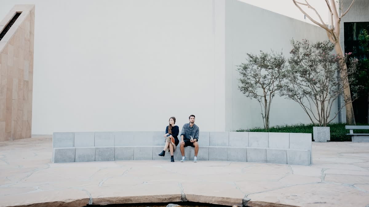 Modern urban plaza with people sitting in a minimalist architectural setting