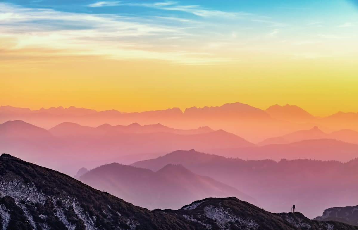 person hiking in a vast mountain range