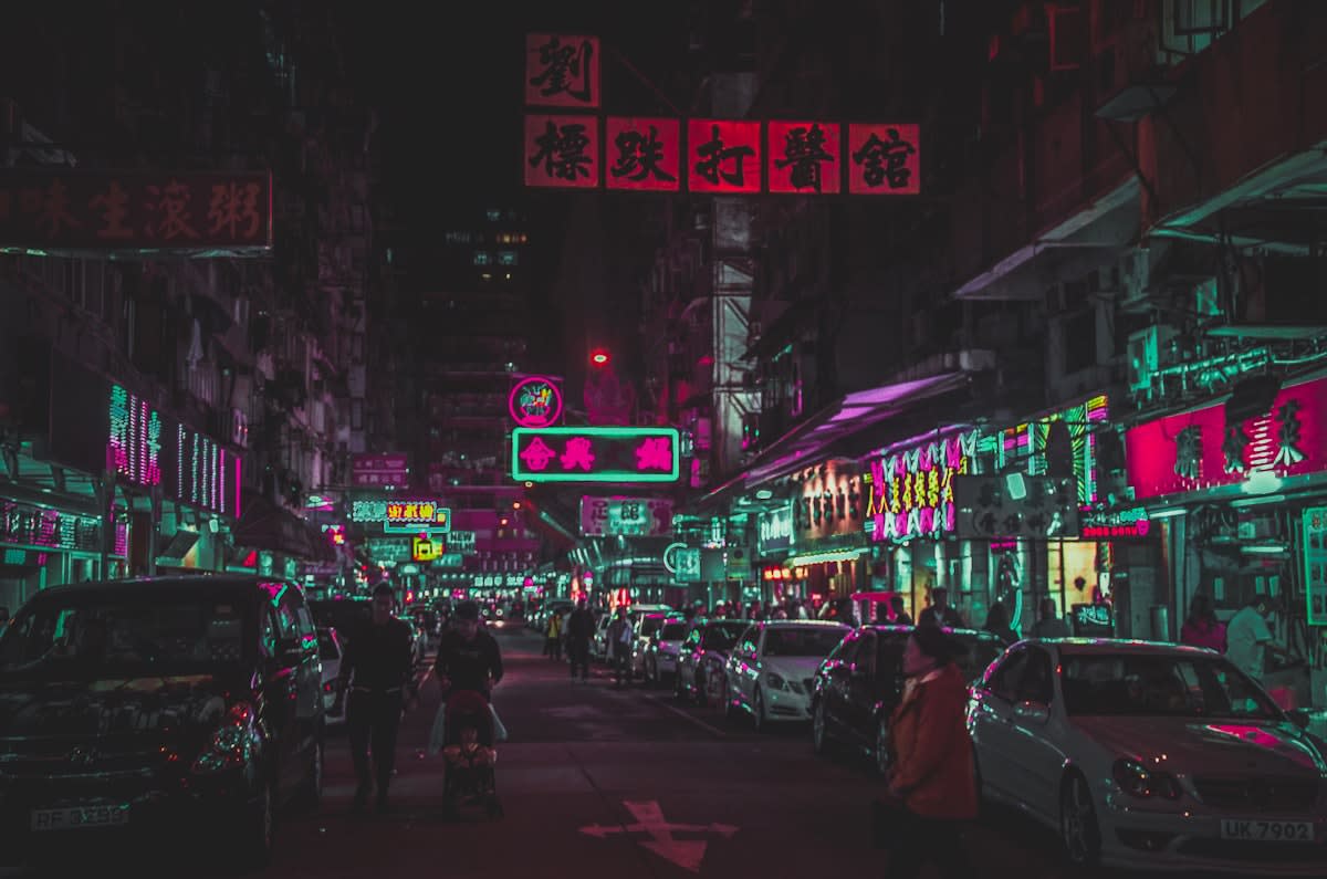 Cyberpunk city street with neon lights and people on phones