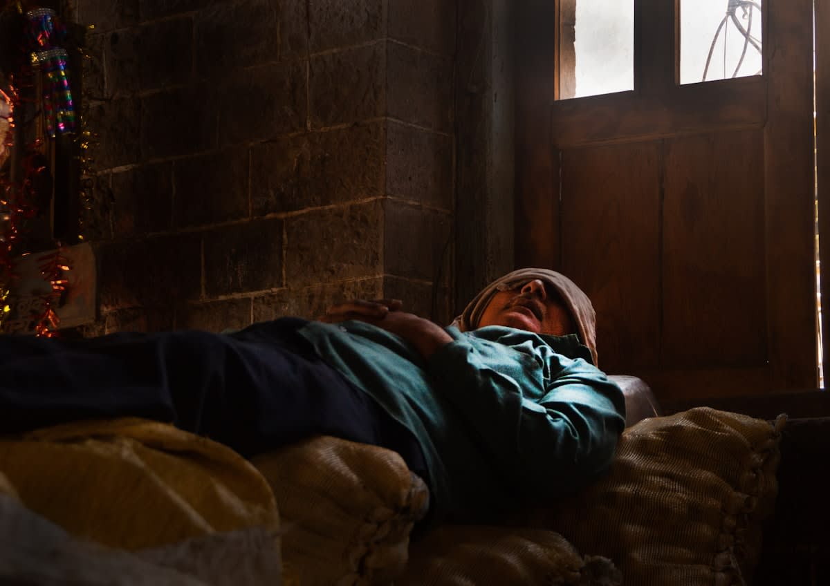 Person lying flat in a dimly lit room with an eye mask