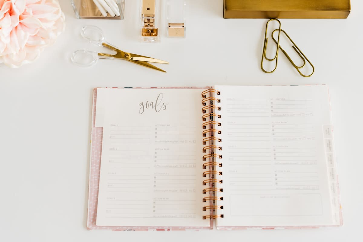 organized desk with a planner and a clock
