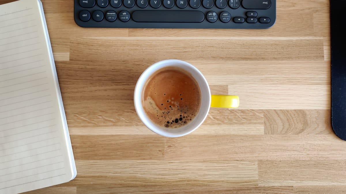 a clean desk with a notebook and a cup of tea