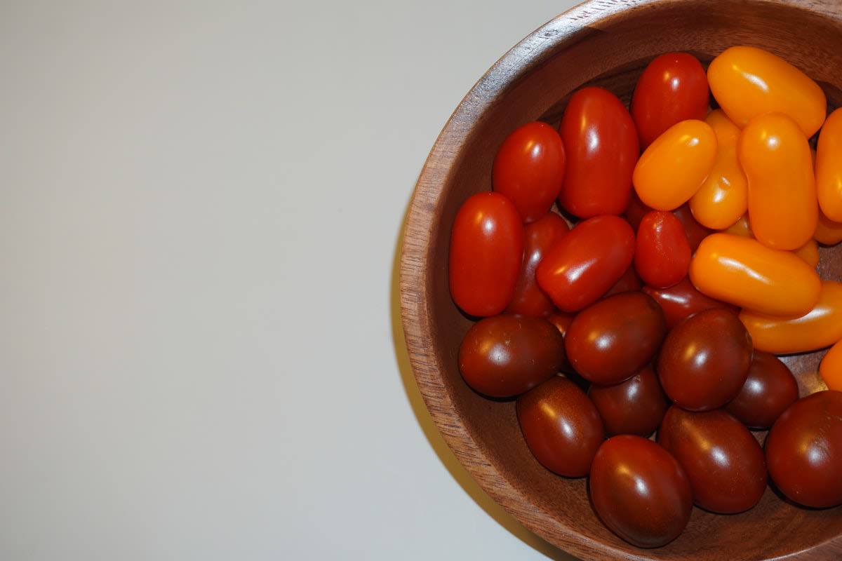 Diverse heirloom corn kernels in a wooden bowl