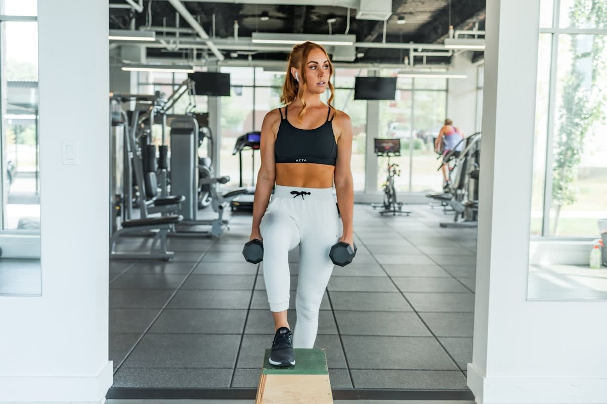 Older adult lifting dumbbells in a modern gym