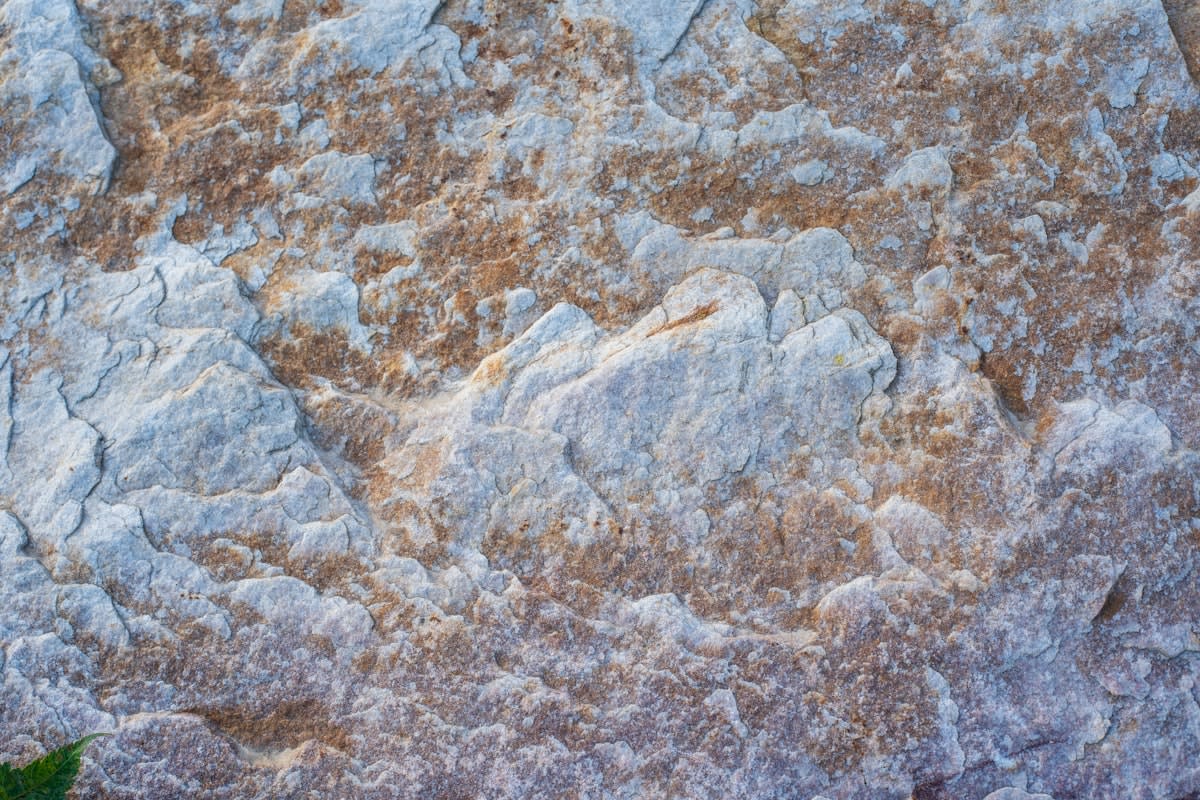 Close up of hands touching a rough stone surface
