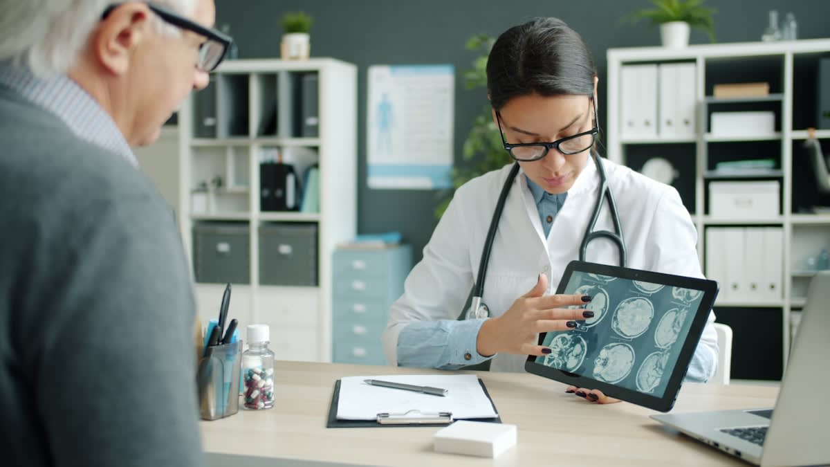 Doctor discussing results with an elderly patient in a bright office