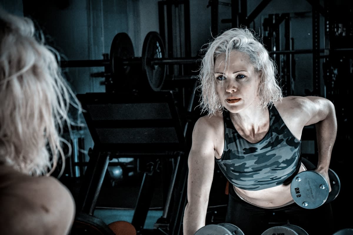 Elderly person lifting weights in a gym