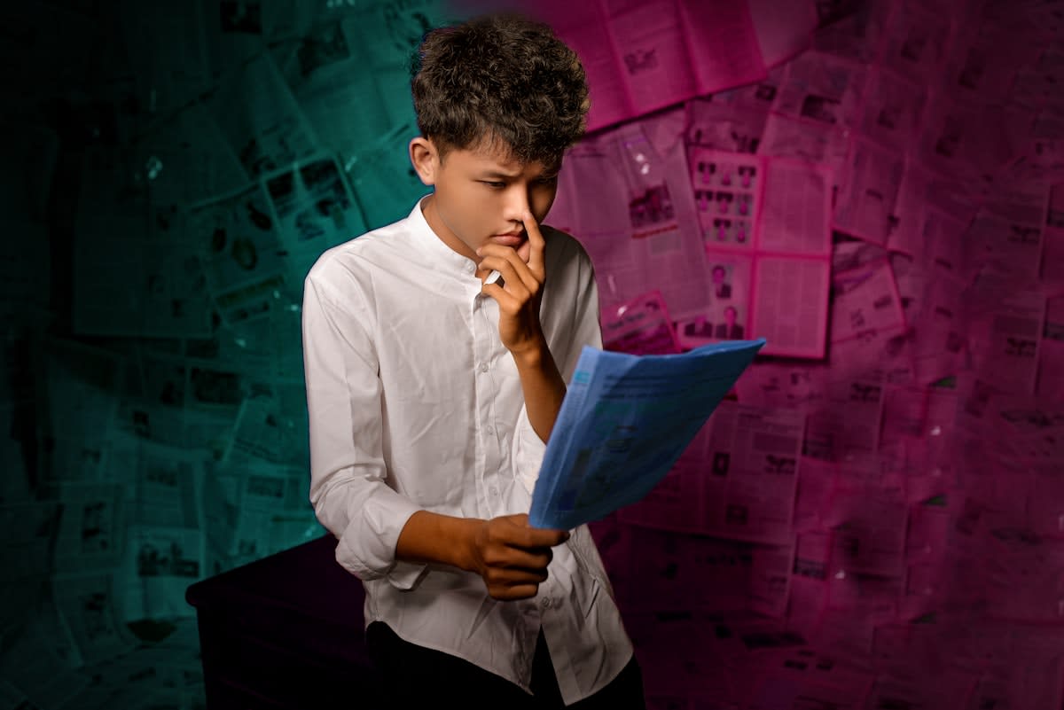 A person looking overwhelmed by multiple digital screens and papers