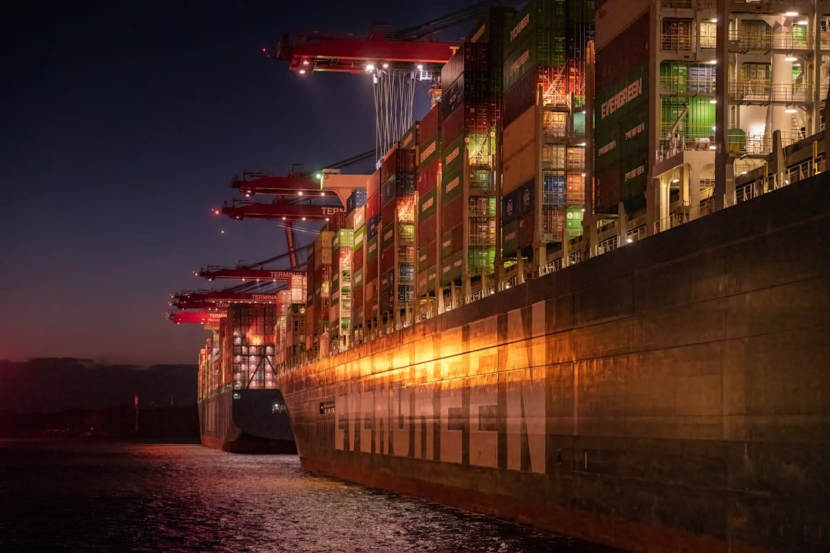 Container ship at night with glowing lights