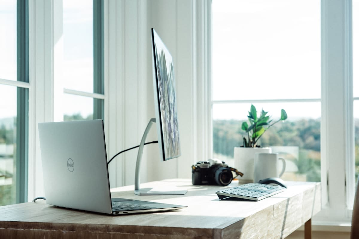 Modern minimalist home office with multiple monitors showing documents
