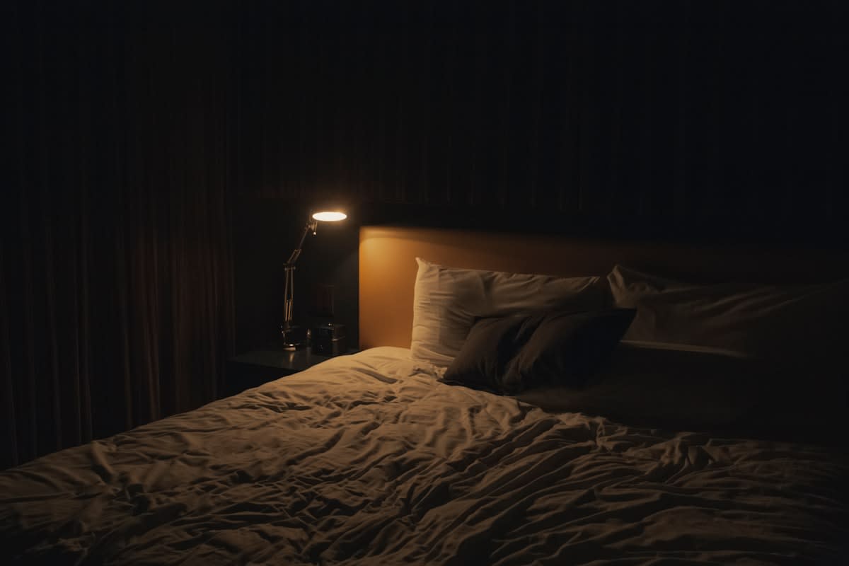 A dark, cool, minimal bedroom environment