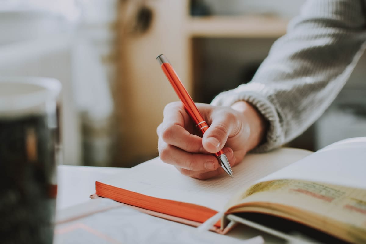 A person writing in a journal with a fountain pen
