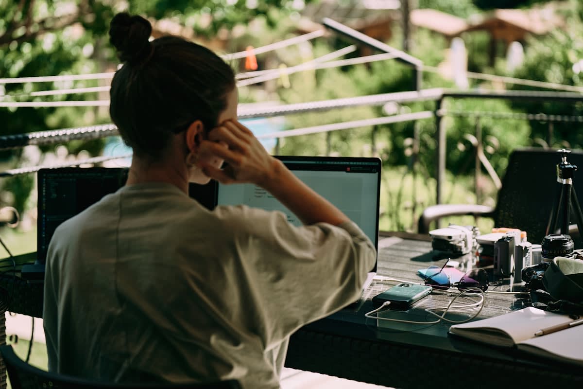 Person looking exhausted at a modern desk with multiple screens
