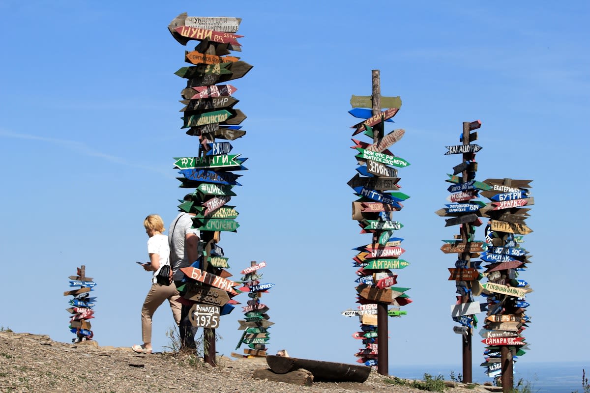 A person standing at a crossroads with hundreds of signposts pointing in different directions