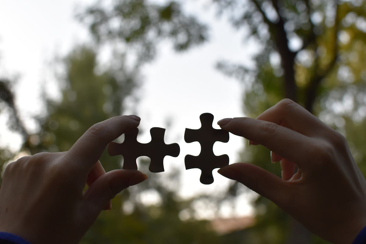 Person connecting different puzzle pieces representing various industries