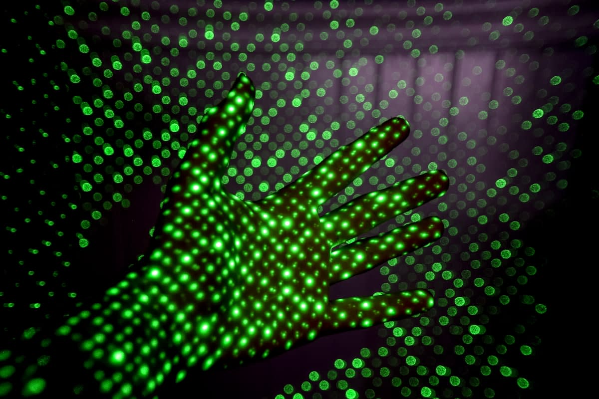 Abstract digital representation of a human hand blending into binary code while writing