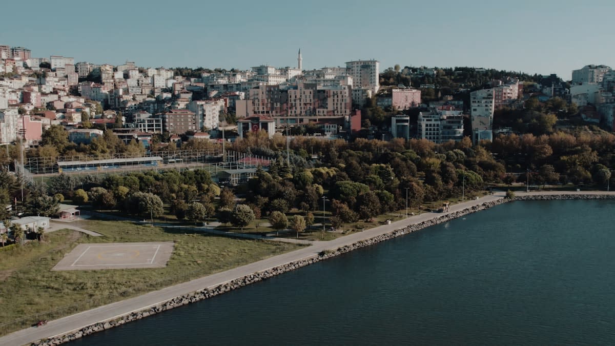 Aerial view of a futuristic green urban waterfront with noise buffers