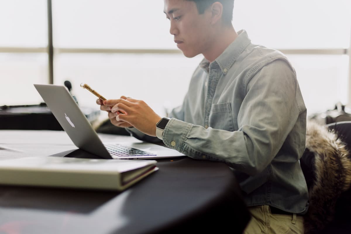Person reviewing documents with a laptop