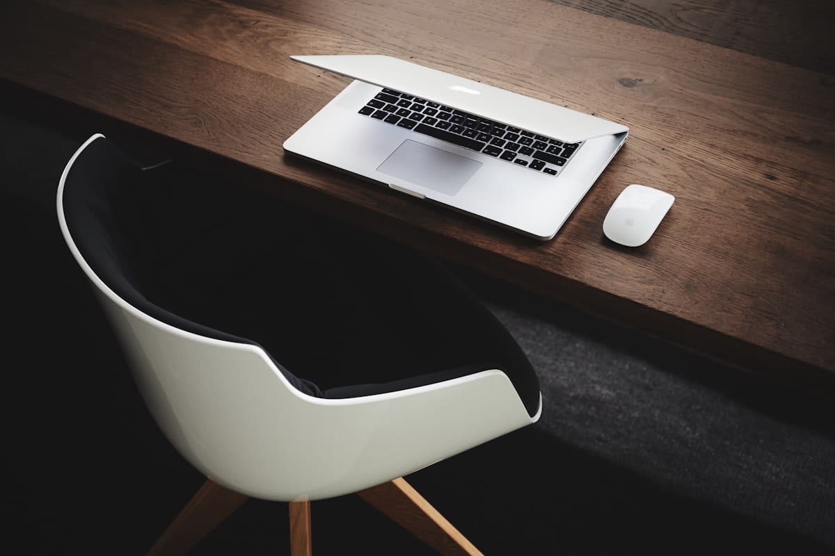 Minimalist workspace with a single laptop and a notebook