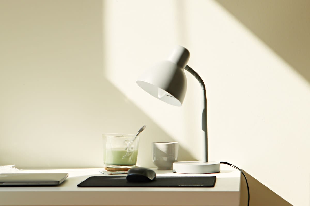 minimalist workspace with a single lamp and a blank notebook
