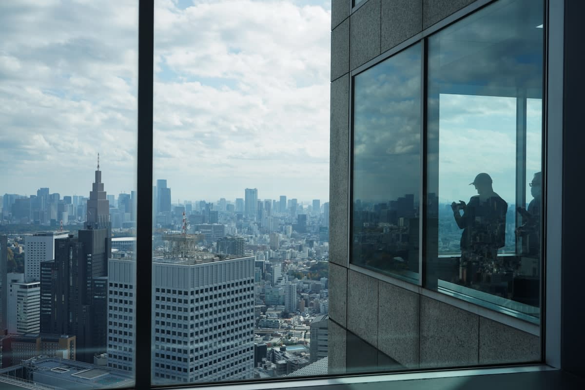 Stressed executive in a modern glass office overlooking a global city skyline