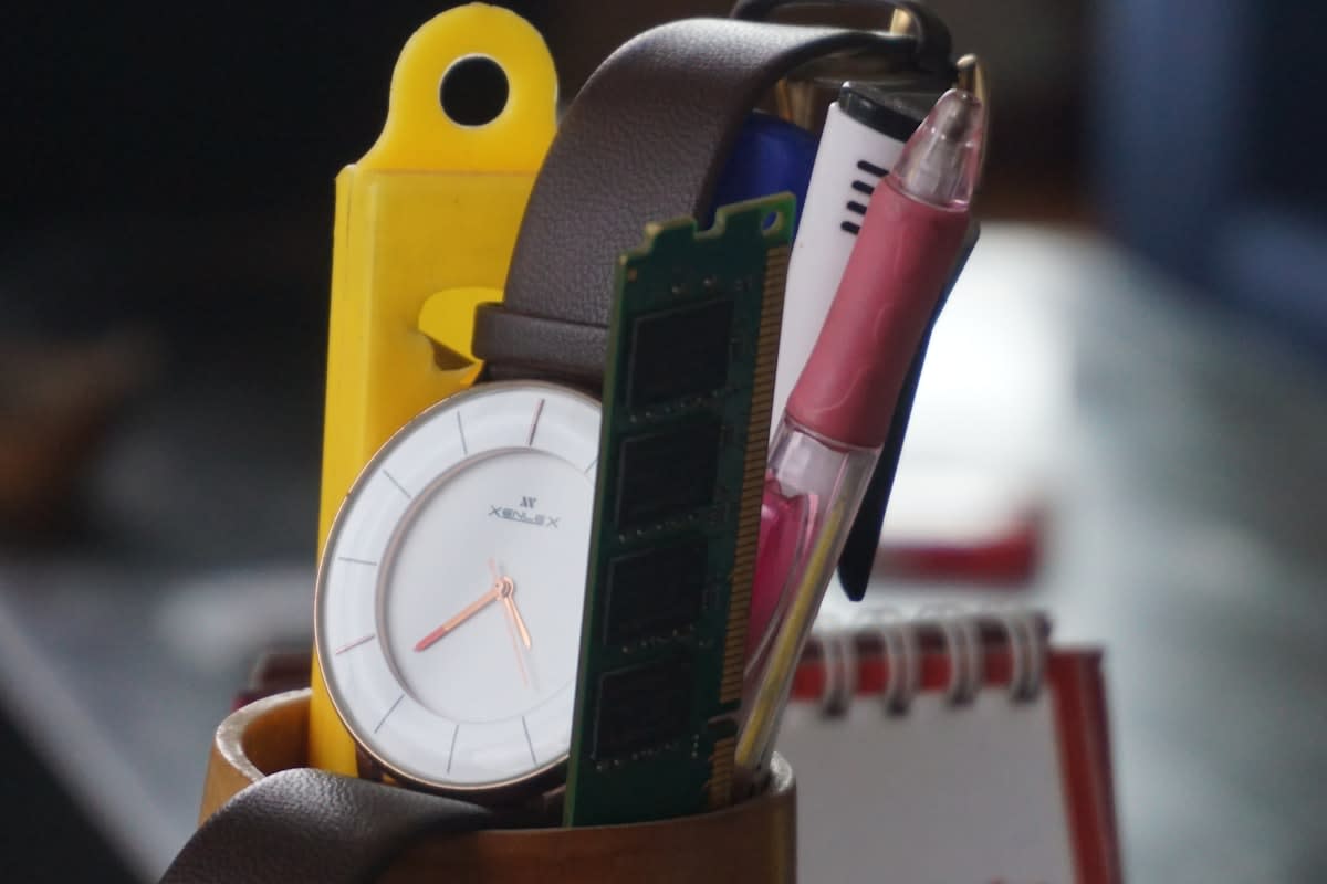 Close up of a high-end watch and a fountain pen on a desk